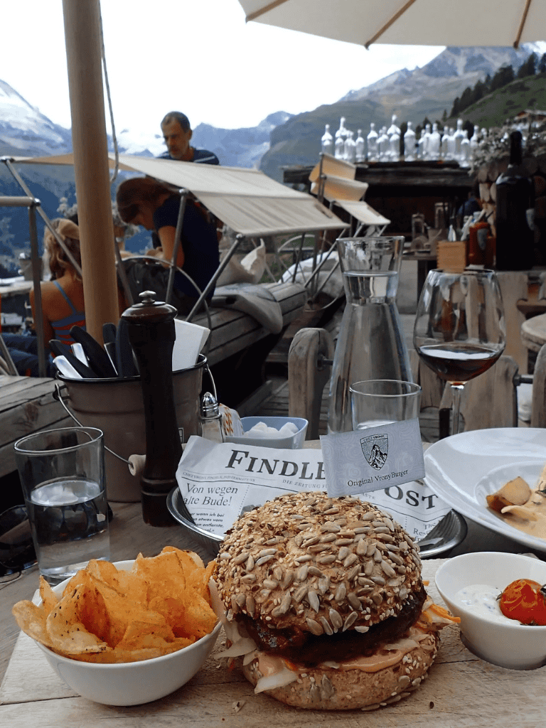 Savory burger with sunflower seeds served with chips and dipping sauce at mountain outdoor cafe.