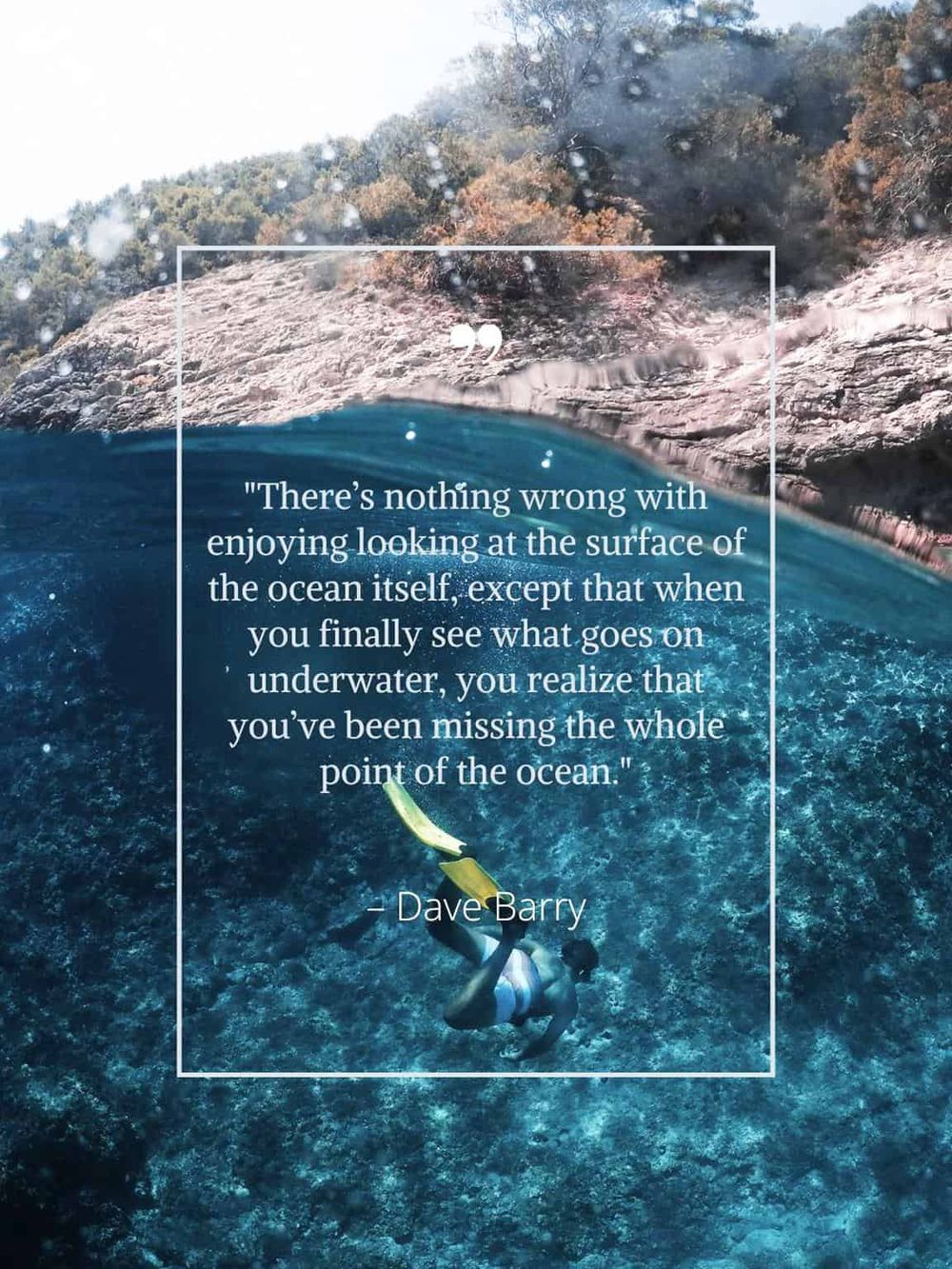 Crystal clear ocean surface with a diver and scenic rocky shoreline in the background.