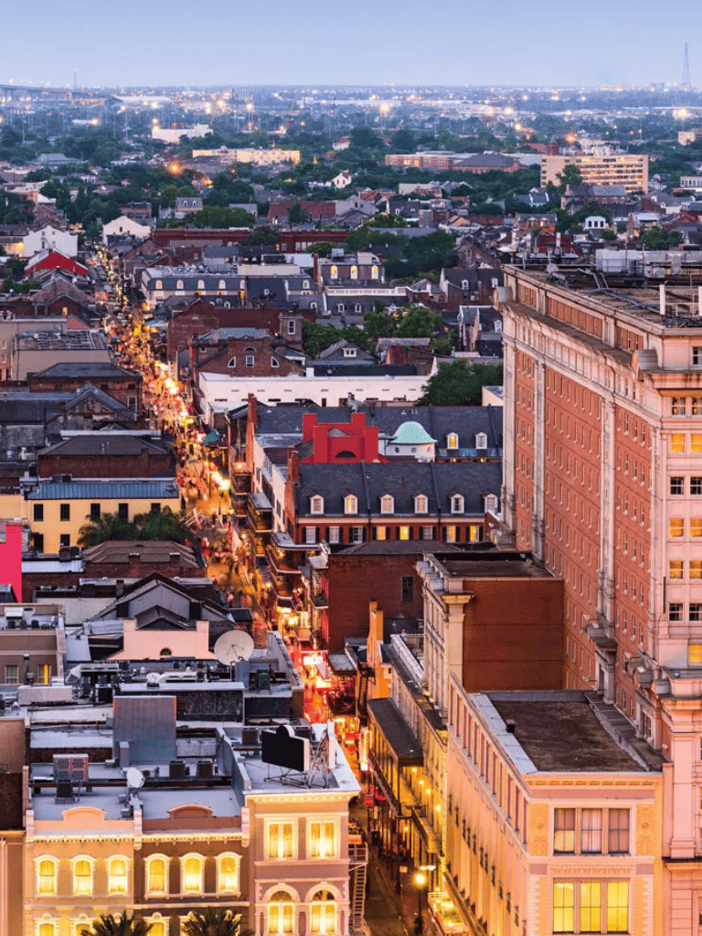 Vibrant cityscape of downtown with illuminated streets and historic buildings at dusk.