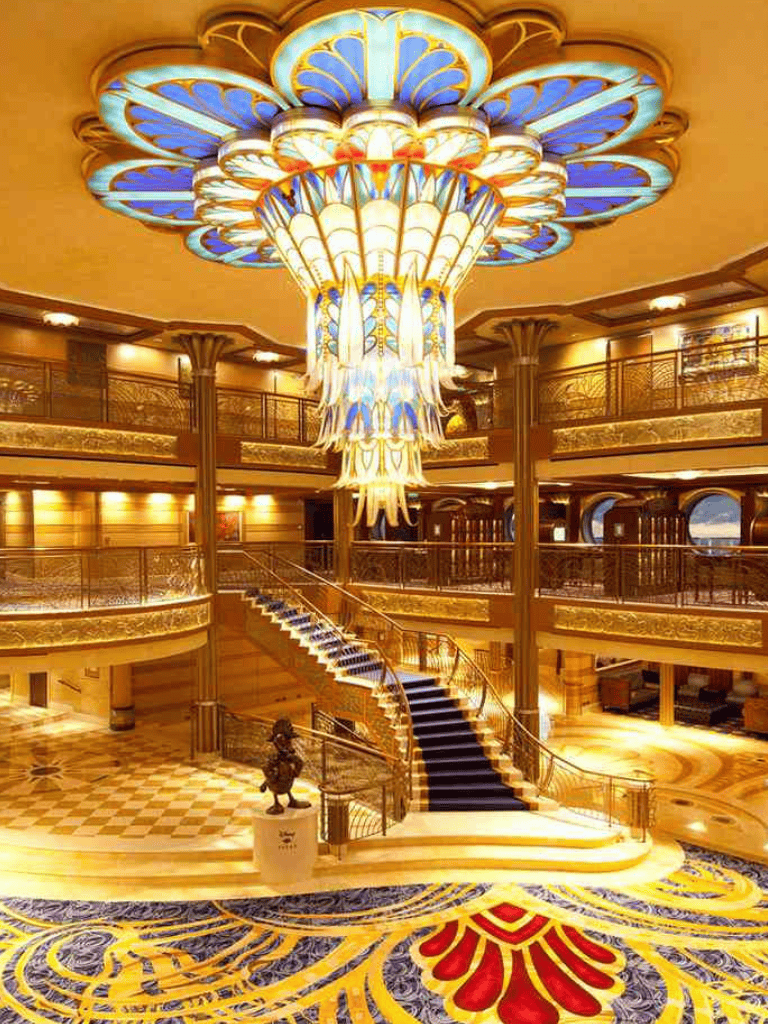 Luxurious hotel interior with grand staircase and ornate chandelier.