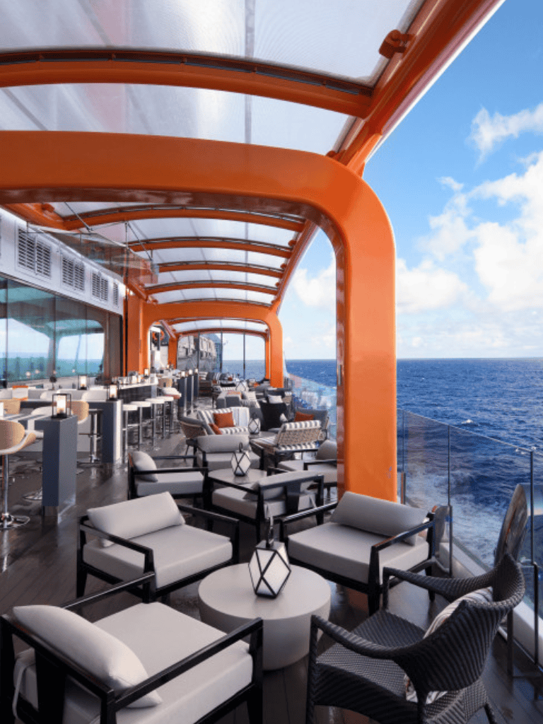 Open-air cruise deck with ocean views and stylish seating, perfect for relaxing or socializing.