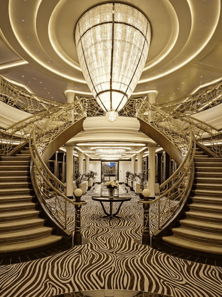 Elegant hotel lobby with grand staircase and luxurious decor.