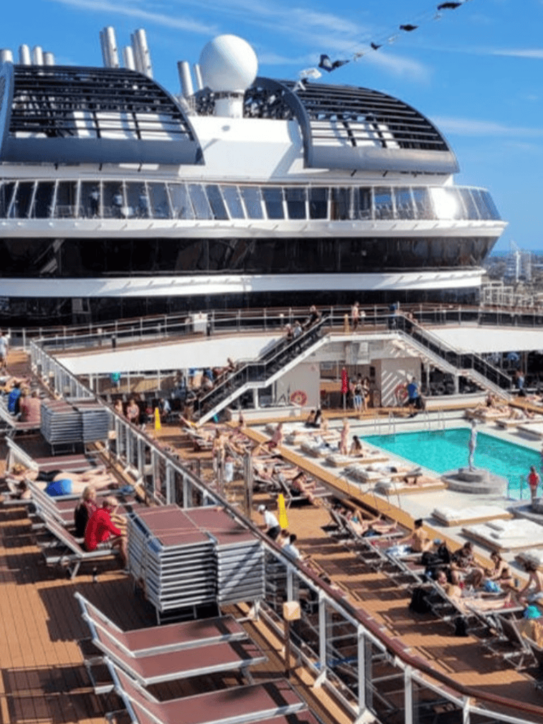 Luxury cruise ship deck with pool and sunbathers on a sunny day at sea, featuring modern amenities and leisure activities.