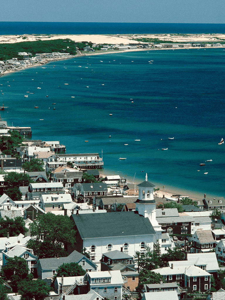 Colorful coastal town with a scenic bay and sailboats, perfect for travel and vacation planning.