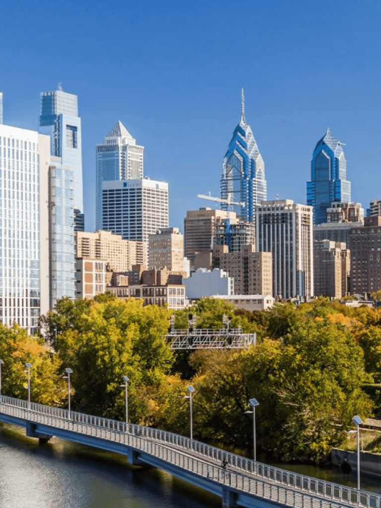 Philadelphia skyline with skyscrapers and a riverwalk, showcasing urban and green space synergy.