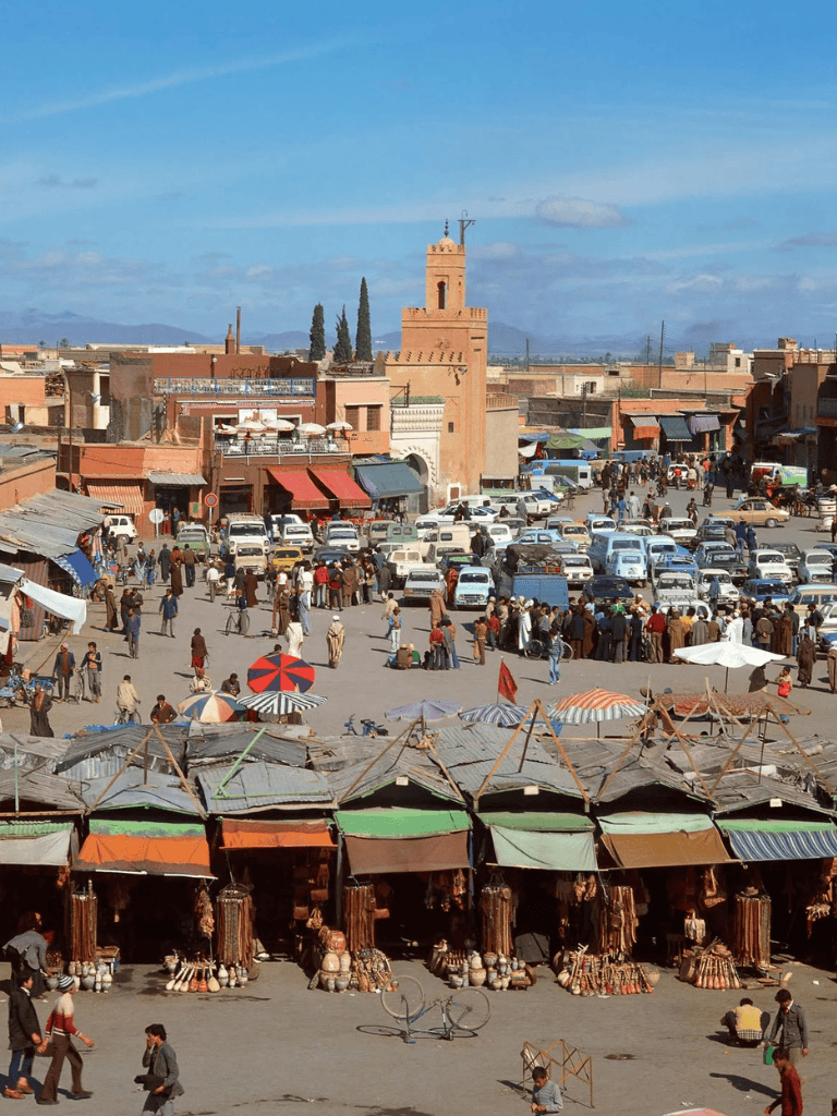 Vibrant marketplace in Marrakesh with traditional stalls, busy crowd, and historic architecture in Morocco.