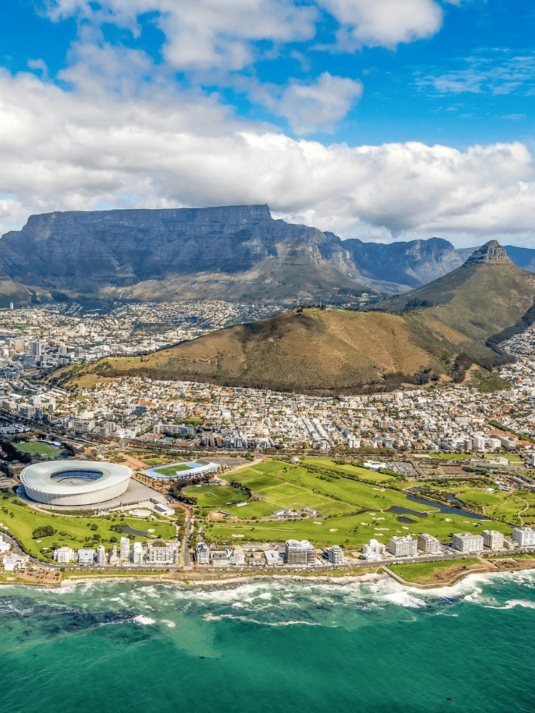Iconic Table Mountain and cityscape panorama with clear sky and ocean views in Cape Town, South Africa.