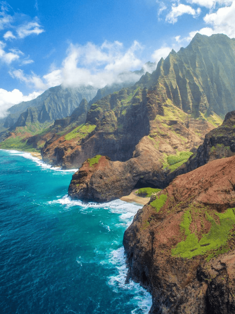 Vibrant coastal cliffs with lush greenery and blue ocean waves, showcasing rugged island scenery.