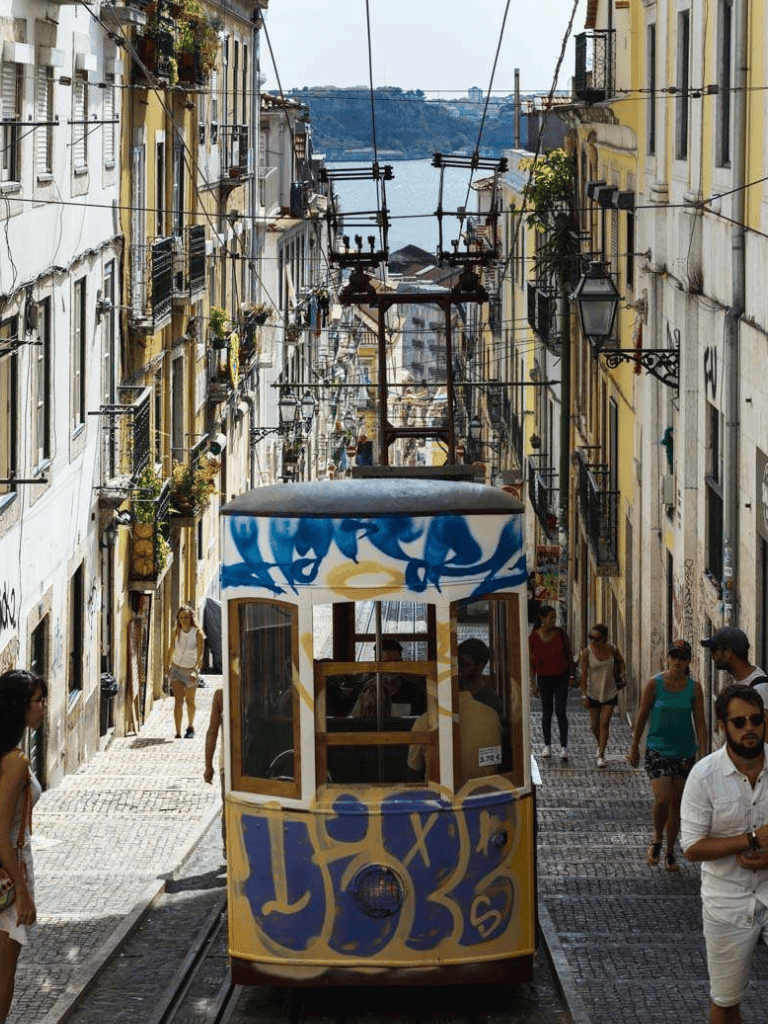 Colorful Lisbon tram navigating narrow historic streets in Portugal, scenic city tour.