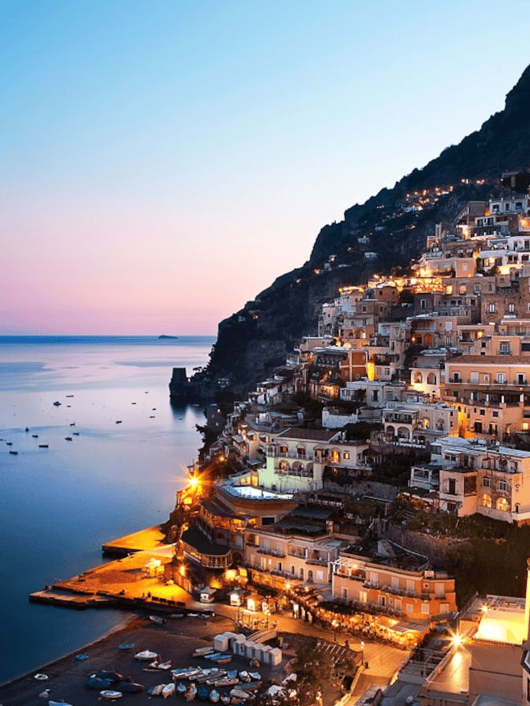 Vibrant coastal village illuminated at dusk on Amalfi Coast, Italy.