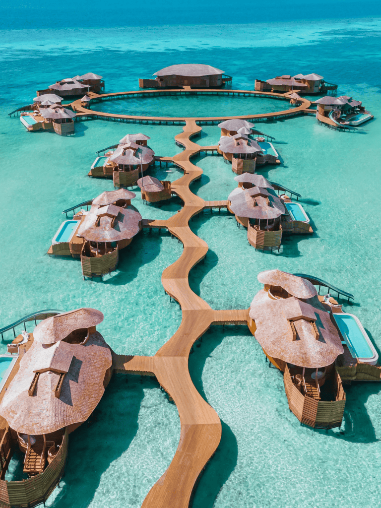 Seaside overwater bungalows with private pools and walkways, luxury tropical resort in turquoise waters.
