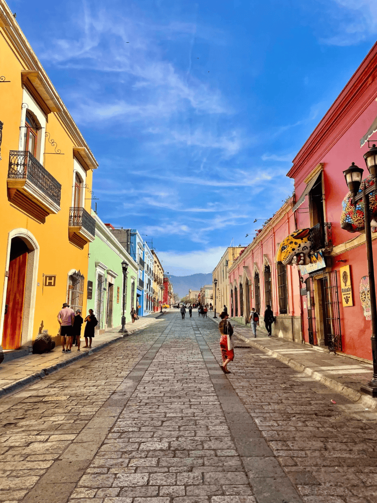 Colorful historic street in Mexico City with vibrant buildings and pedestrians, perfect for exploring local culture.