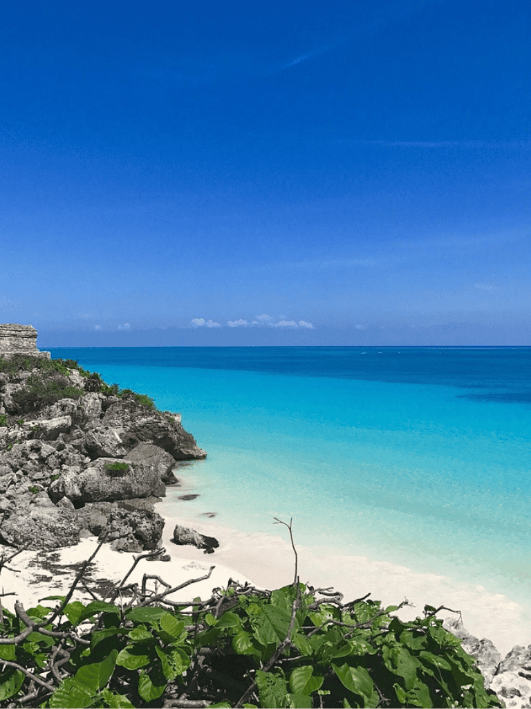 Serene tropical beach with turquoise waters and rocky cliffs, perfect for travel and exploration.