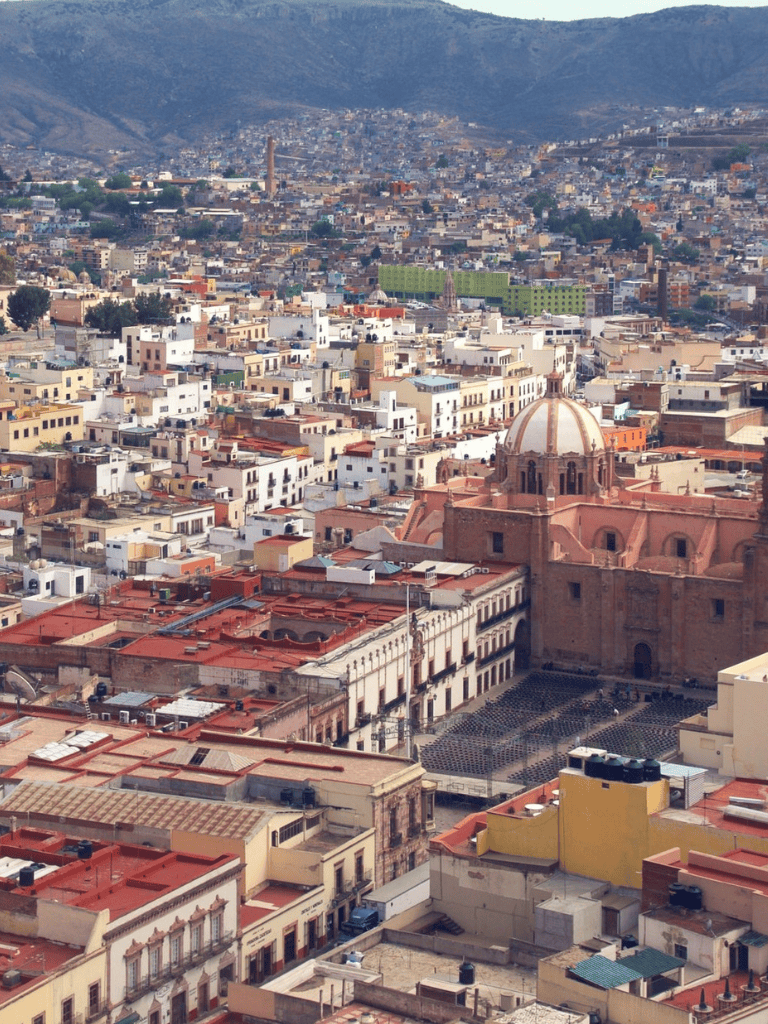 Colorful aerial view of Mexico City with historic buildings and bustling streets, showcasing urban landscape and architecture.