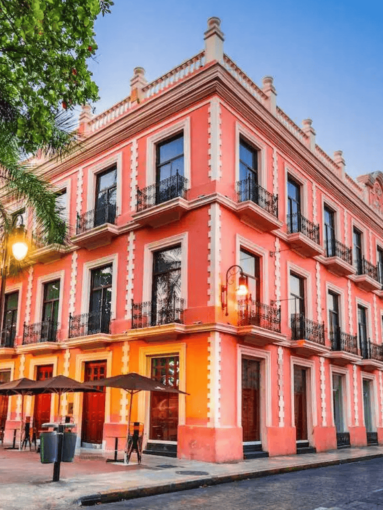 Colorful historic building with balconies and street patio in downtown cityscape.