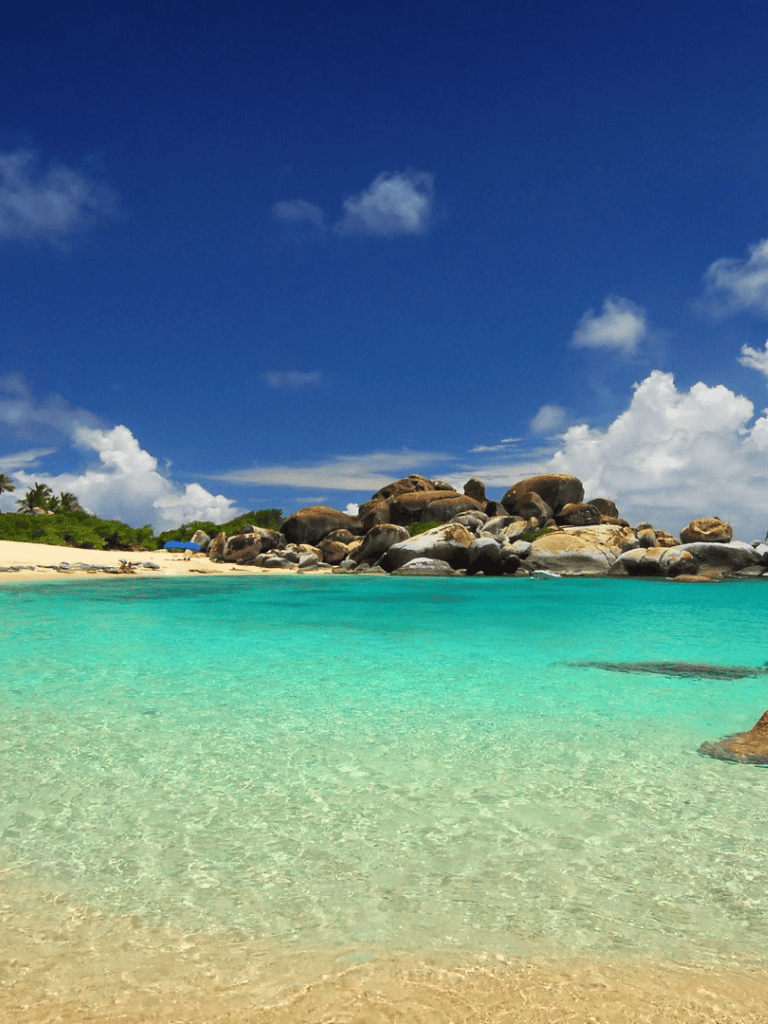 Pristine tropical beach with turquoise waters and rocky shoreline at QuestForDirections.