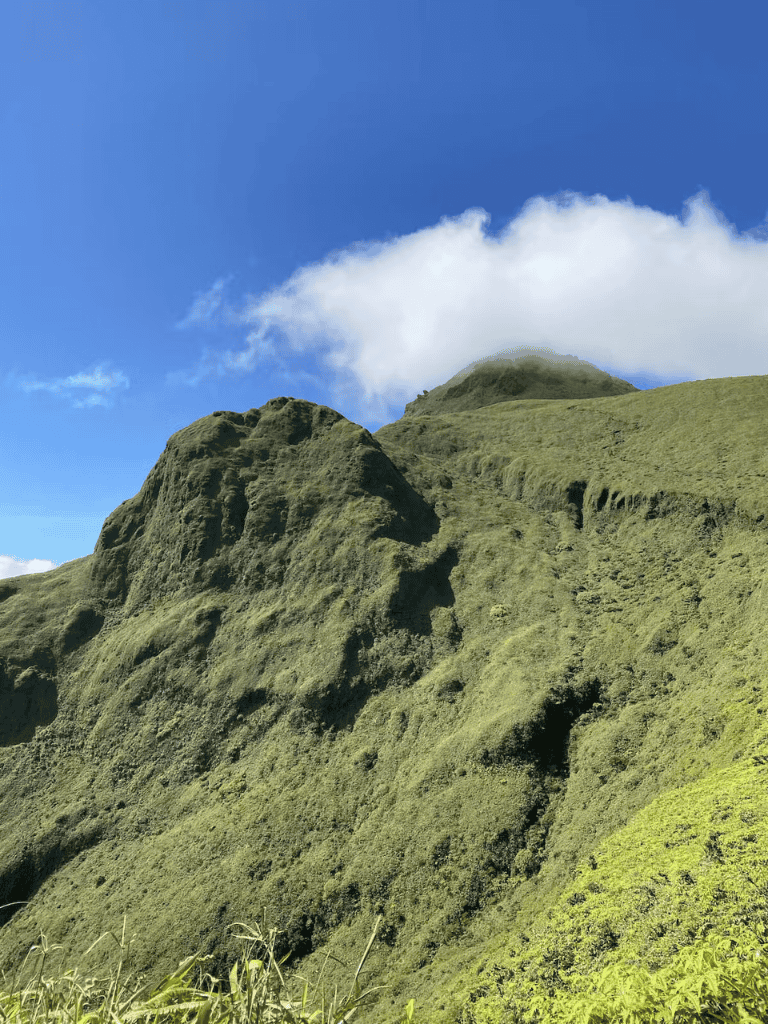 Lush green mountain landscape under blue sky with clouds at QuestForDirections.