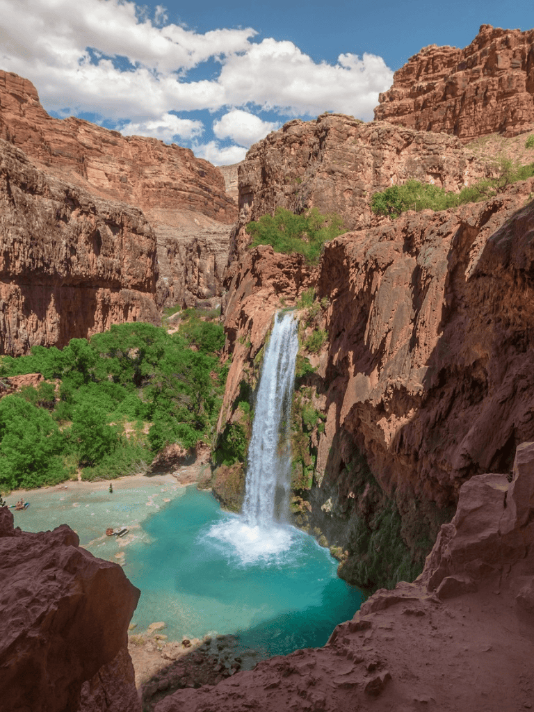 Vivid waterfall cascading into turquoise pool in red canyon landscape, Arizona scenic nature view.