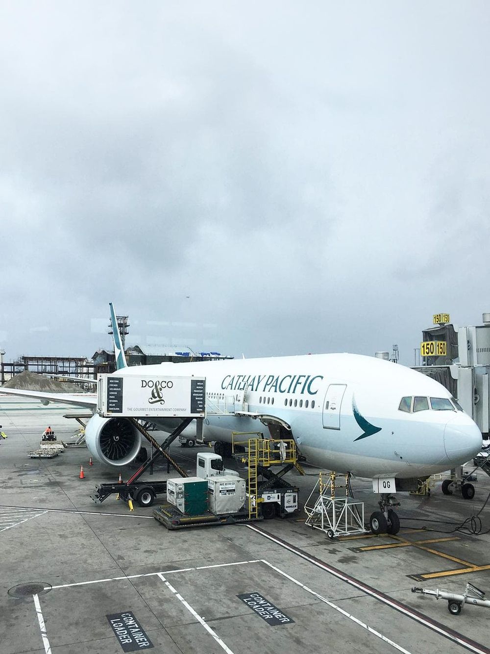 Aircraft at airport gate for international travel, Cathay Pacific airplane boarding process.