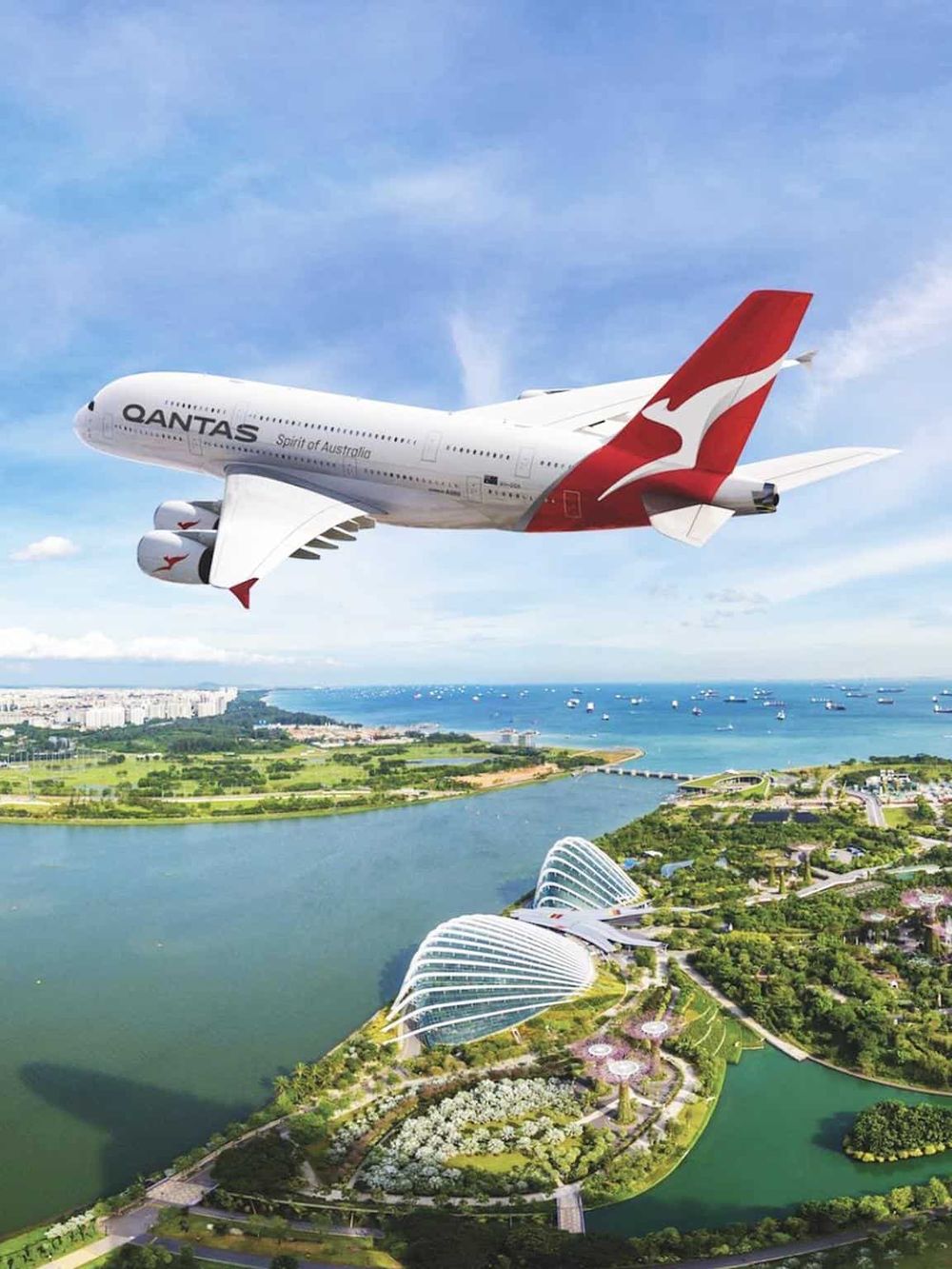 Qantas airplane flying over Sydney Opera House with city and harbor view.