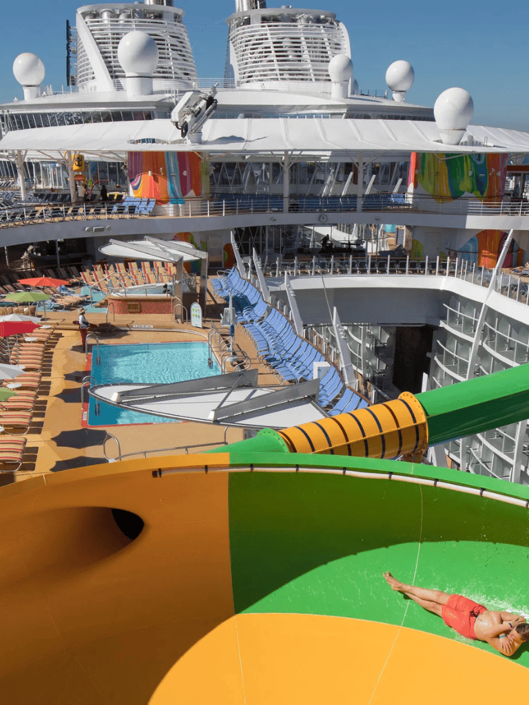 Bright cruise ship with water slides and pool deck, perfect for family vacations and ocean adventures.