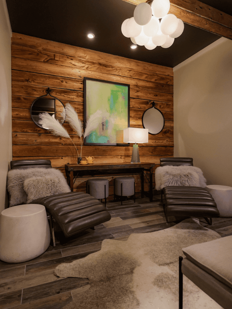 Cozy modern lounge with wooden accent wall, contemporary art, and plush seating for relaxation.