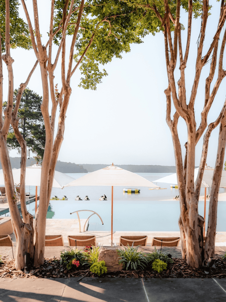 Relaxing lakeside retreat with pool, umbrellas, and scenic views, perfect for outdoor leisure and tranquility.