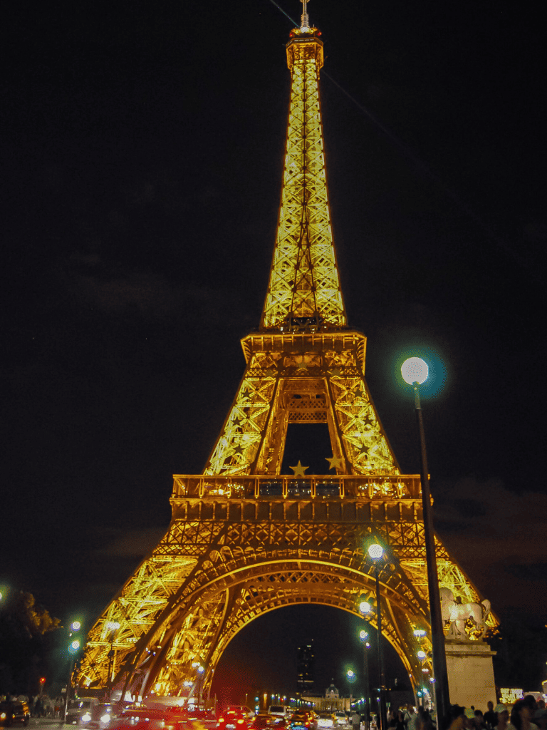 1. Paris Eiffel Tower at night illuminated with golden lights, iconic landmark, night scenery, tourism attraction.