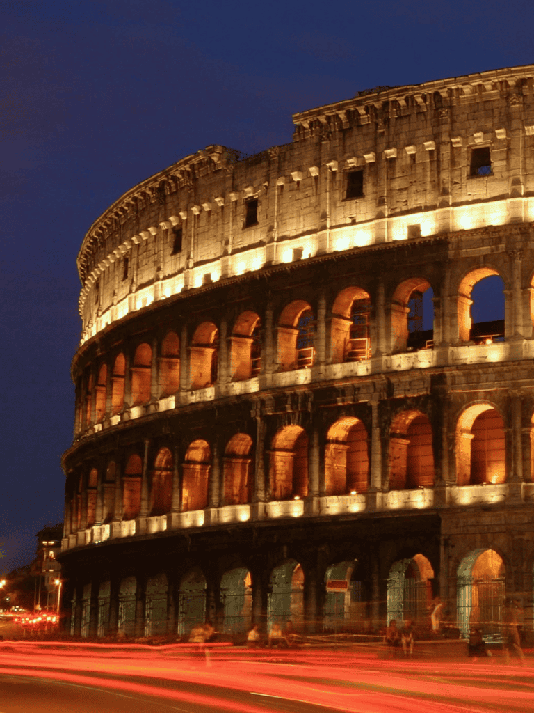 Ancient Roman Colosseum lit up at night, iconic historical landmark in Rome, Italy.