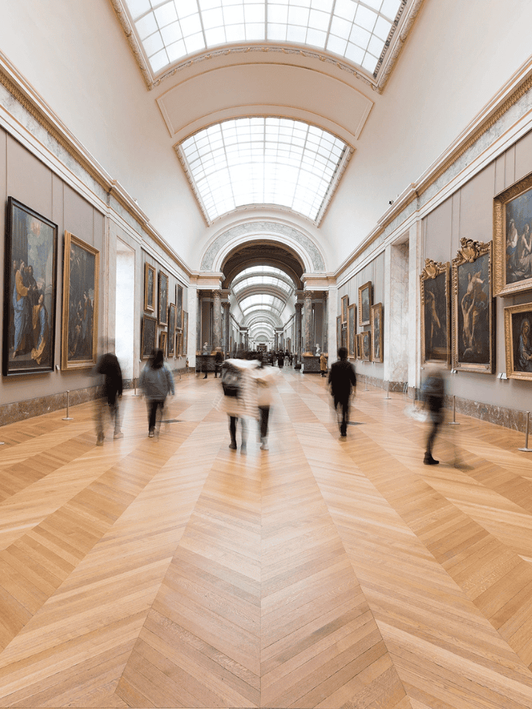 Elegant art museum gallery featuring classic paintings and wood flooring.