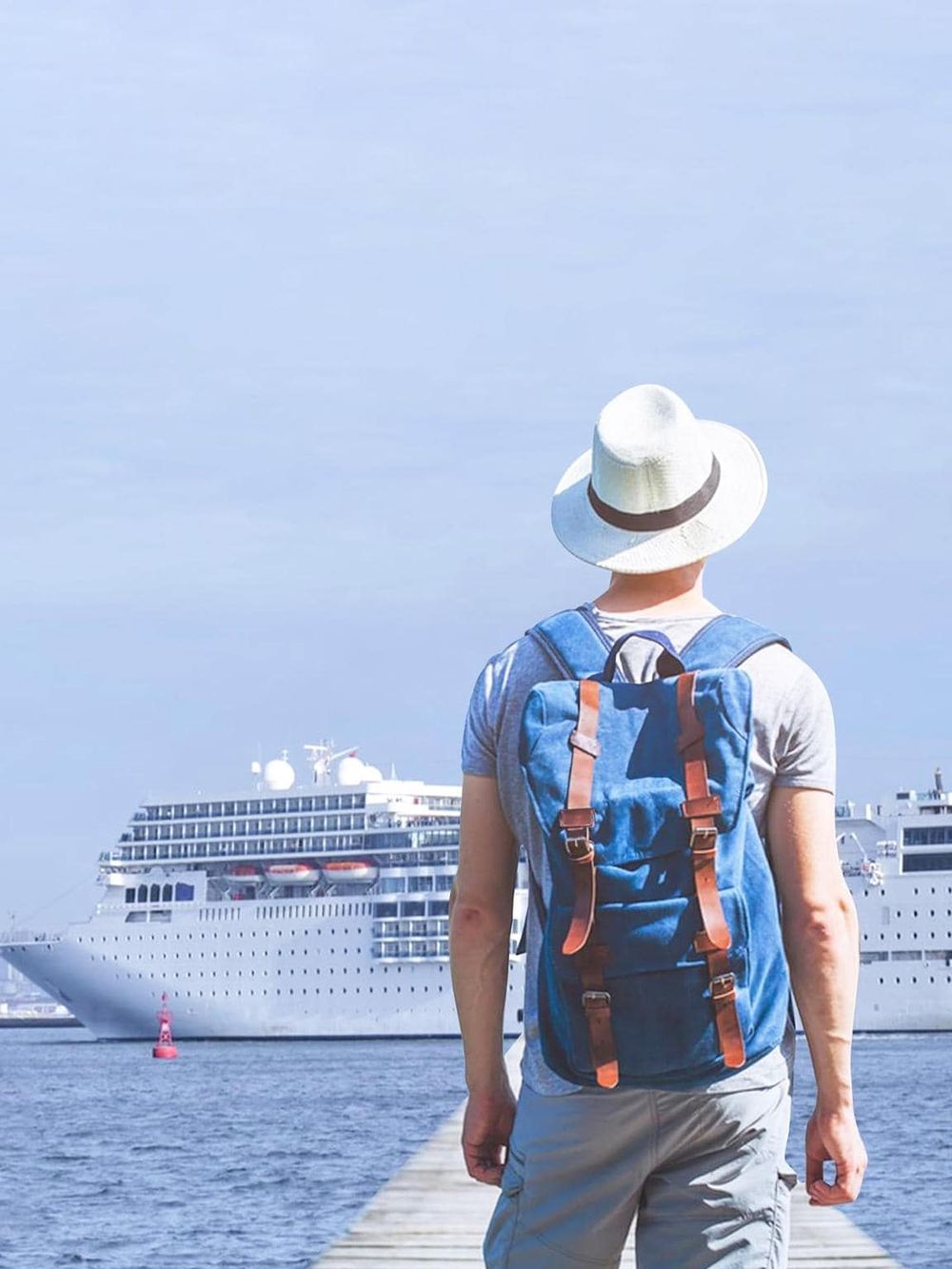 Cruise traveler enjoying a port visit, standing on a dock with a large cruise ship in the background.