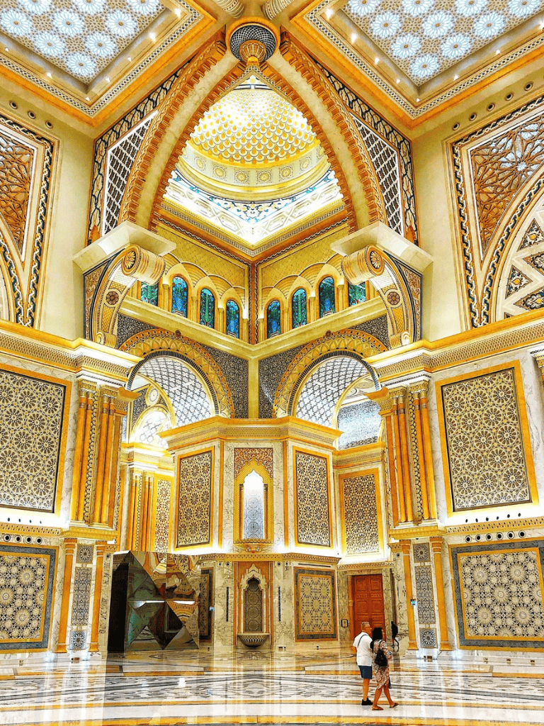 Lavish gold and intricate geometric designs decorate the grand interior of a luxurious Islamic palace.