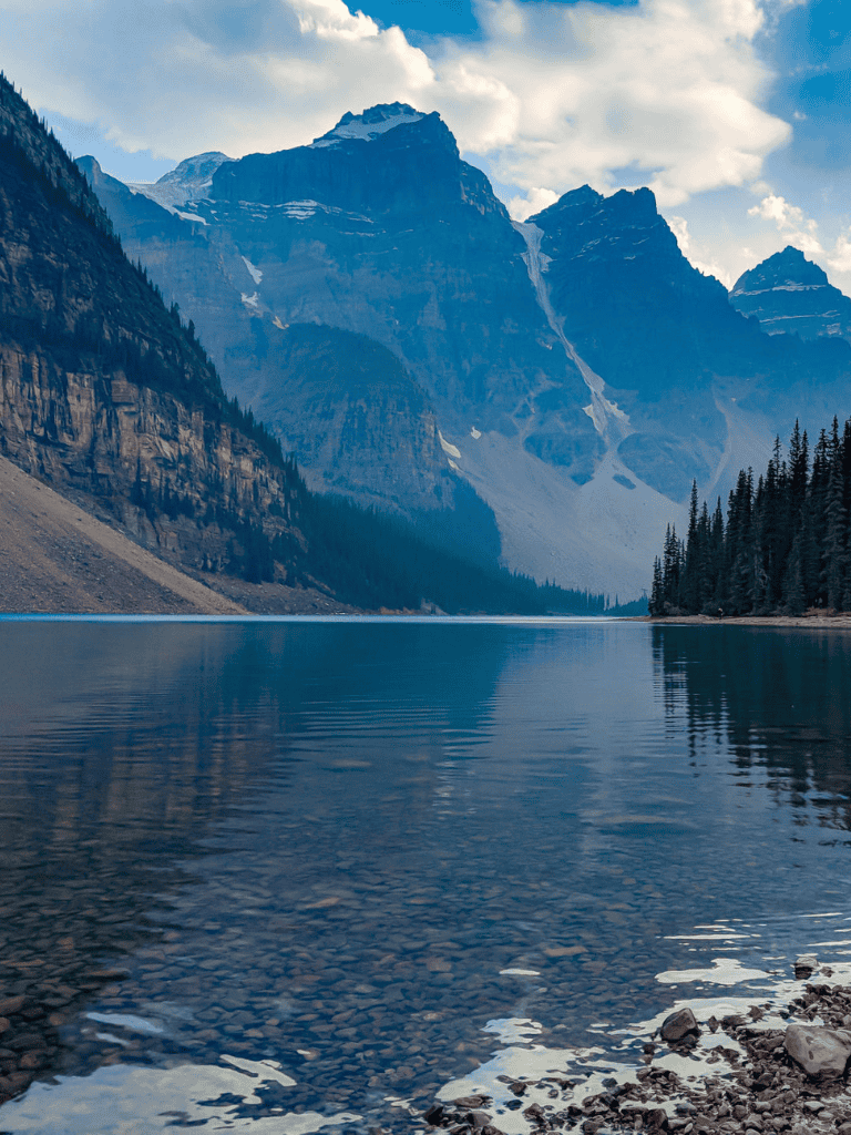 Serene mountain lake with towering peaks and clear water, perfect for exploration and outdoor adventures.