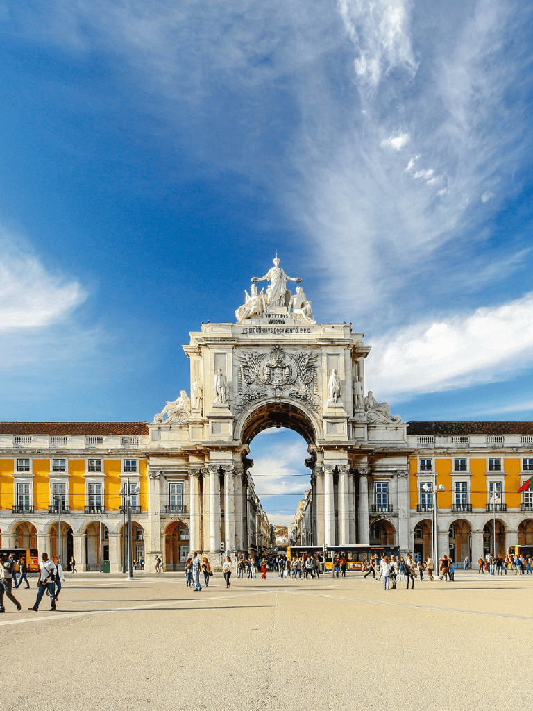 Majestic historic arch entrance with ornate sculptures in Lisbon Portugal, popular tourist destination.