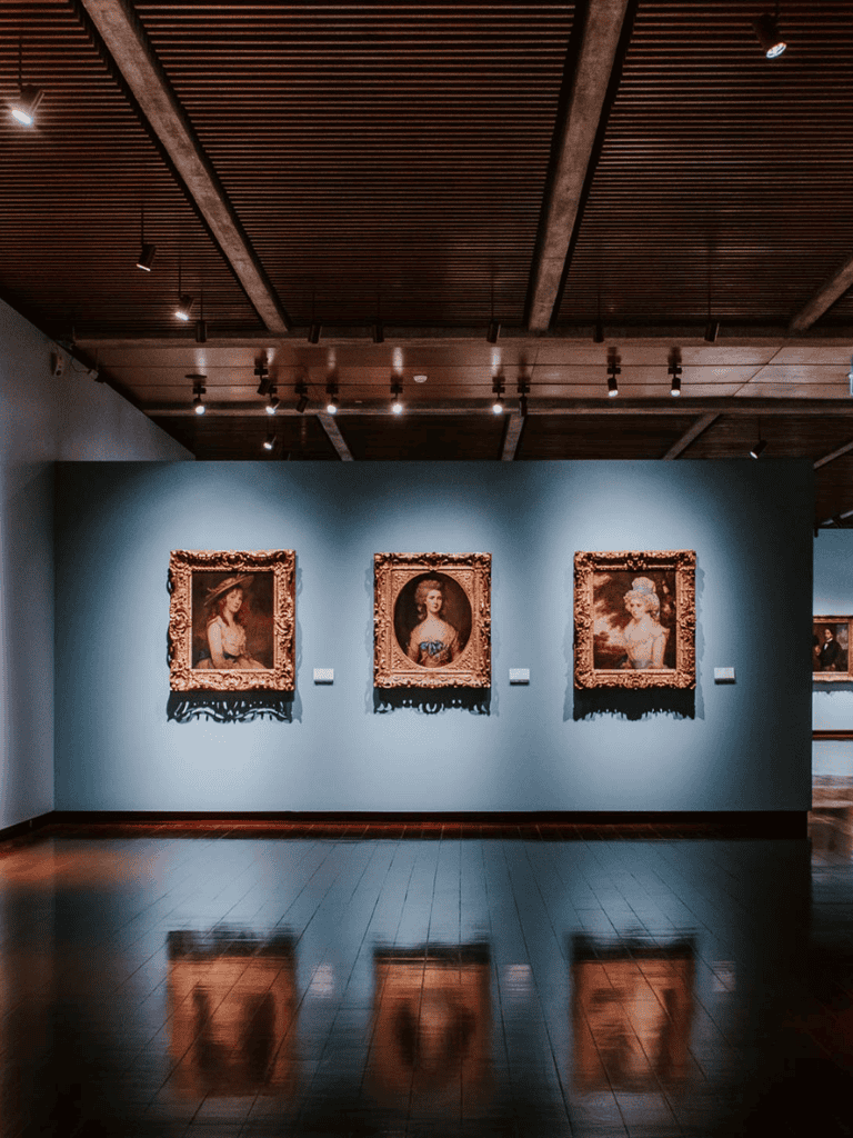 Elegant art gallery with classic portrait paintings and warm lighting.