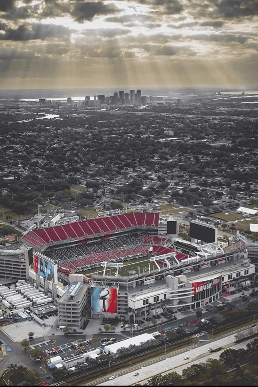 Stadium aerial view showcasing Tampa Bay Buccaneers at Raymond James Stadium, with city skyline in the background.