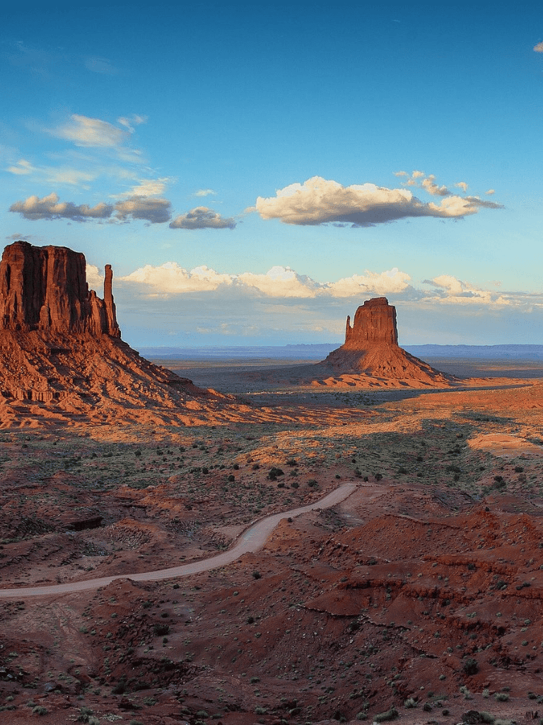 Vast desert landscape with iconic mesas in Monument Valley at sunset.