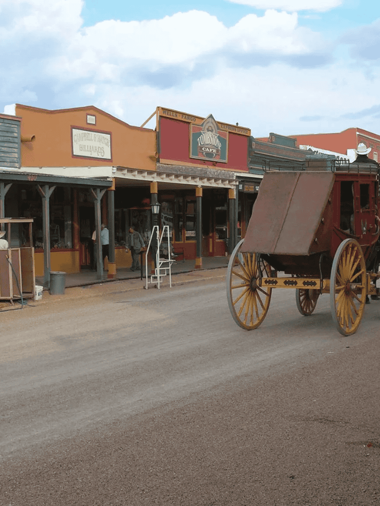 Antique wagon outside historic Western-style storefronts in a themed town.