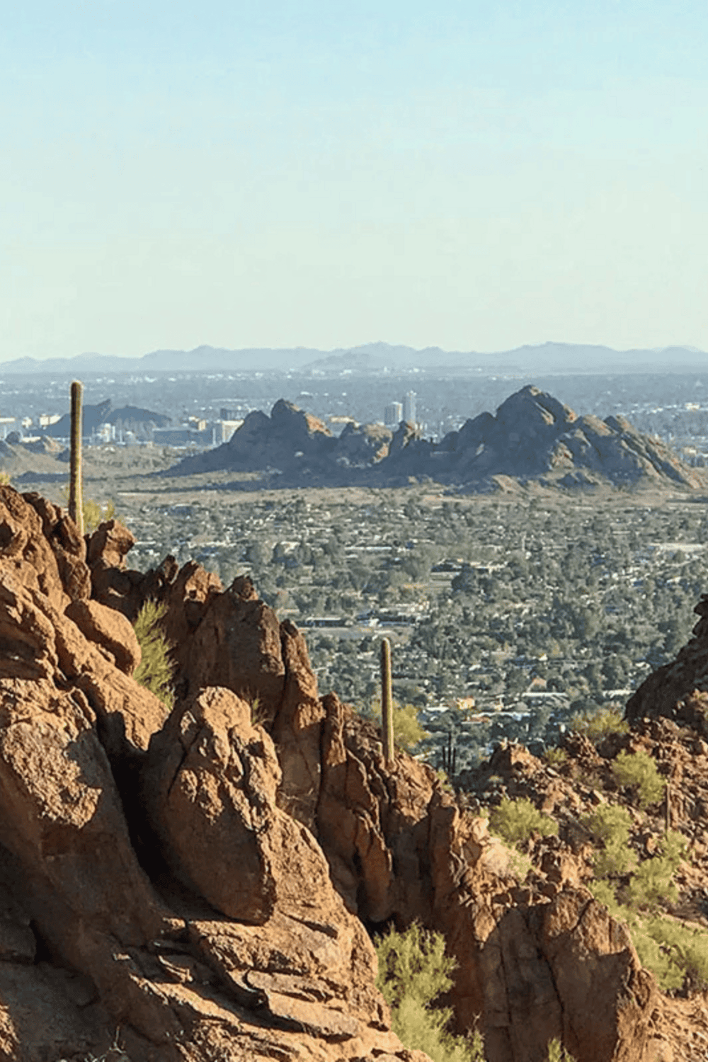 Scenic view of the Phoenix mountains and cityscape, showcasing desert terrain and urban landscape with QuestForDirections branding.