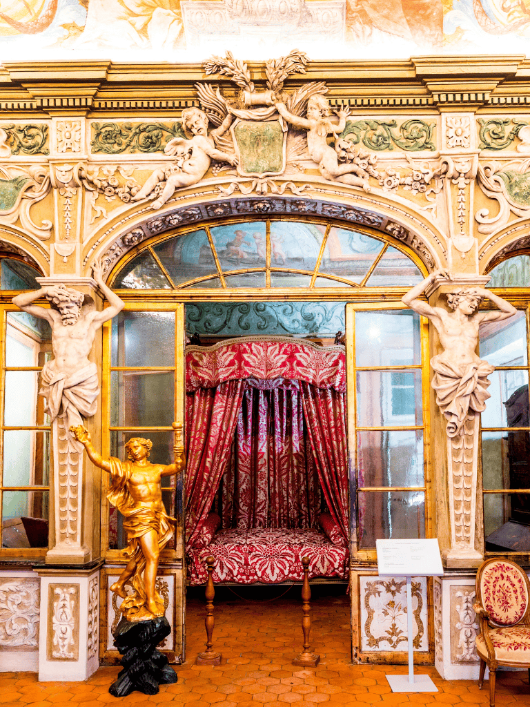 Intricate Baroque architecture with statues and luxurious textiles at QuestForDirections museum exhibit.