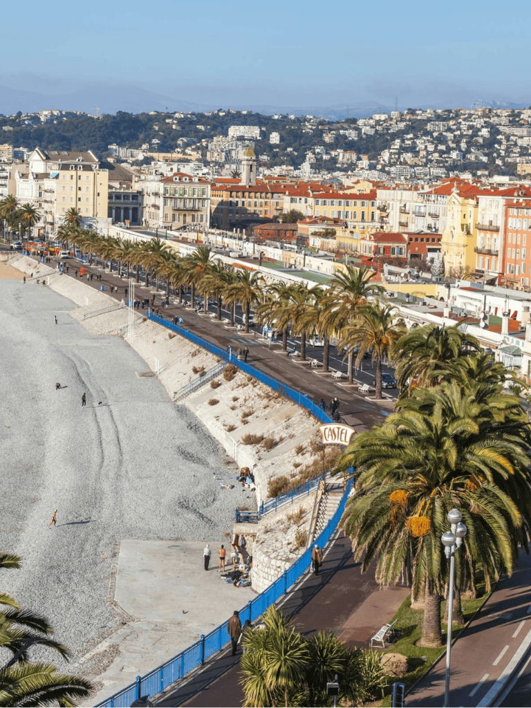 Vibrant cityscape with beach, palm trees, and colorful buildings in a sunny coastal setting.