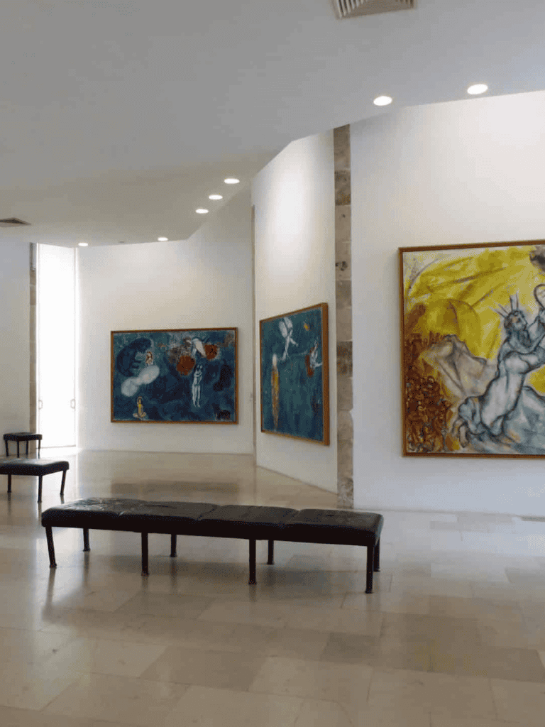 Modern art gallery with vibrant paintings and minimalist seating for art lovers.