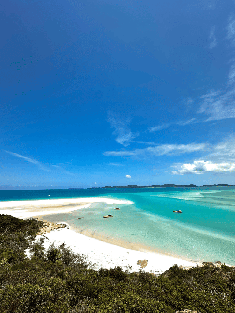 Vivid tropical beach with turquoise waters and white sandy shores under a clear blue sky.