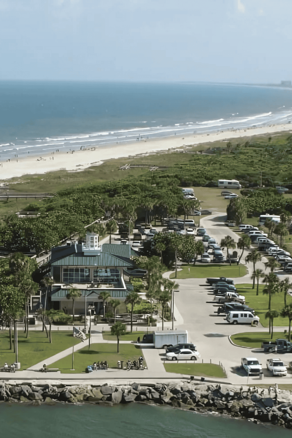 Coastal parking lot near the beach with ocean view and green landscape.