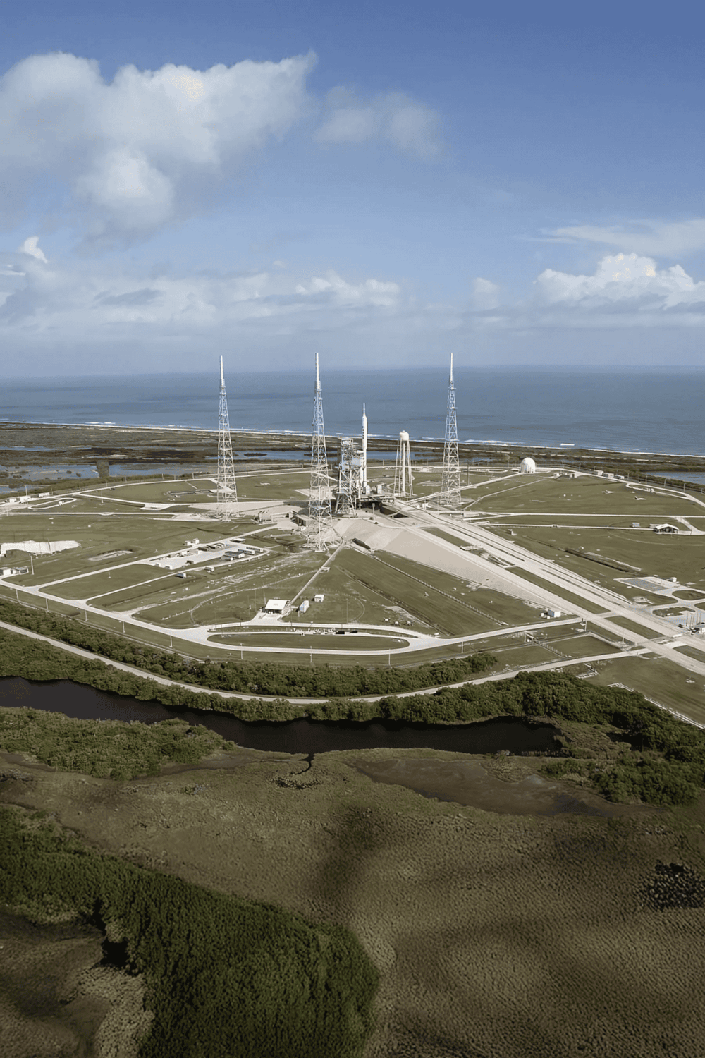 Mysterious rocket launch site with multiple tall communication towers near the coastline.