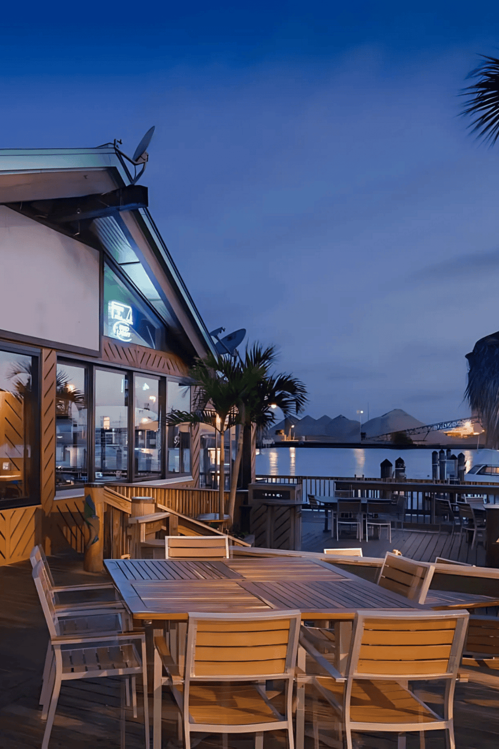 Cozy waterfront restaurant deck with outdoor seating and scenic water views at dusk.