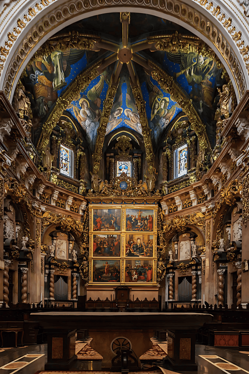 Intricate church interior with gold accents, religious artwork, and stained glass windows, highlighting spiritual design and architecture.