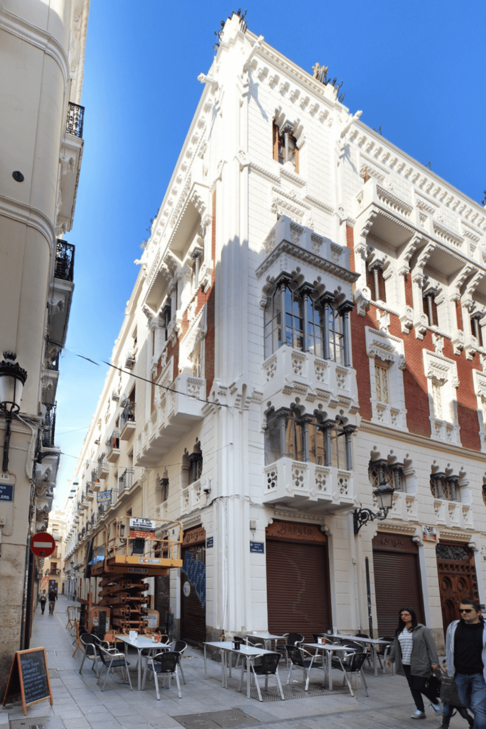 Historical building in Madrid, Spain with ornate architectural details and outdoor cafes.