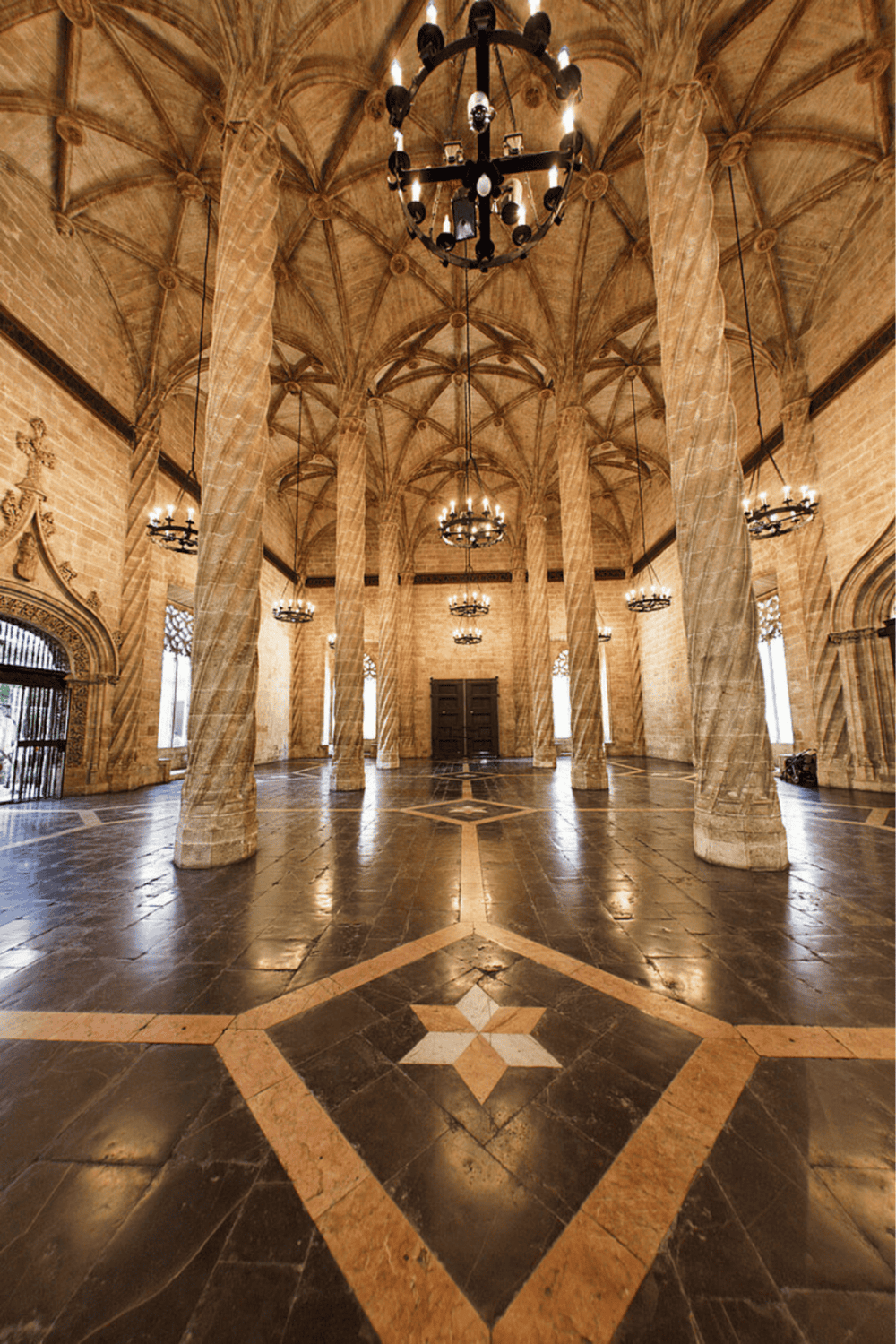 Intricate vaulted ceilings and grand chandeliers in historic castle event space.