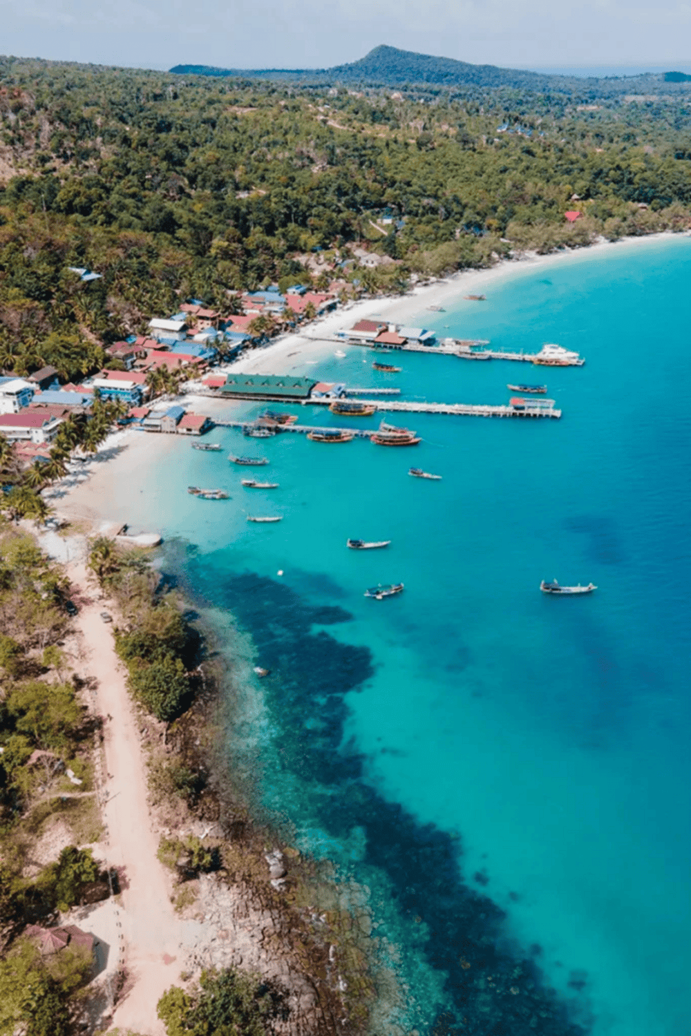 1. Coastal village with boats and lush green hills, stunning tropical paradise scenery.